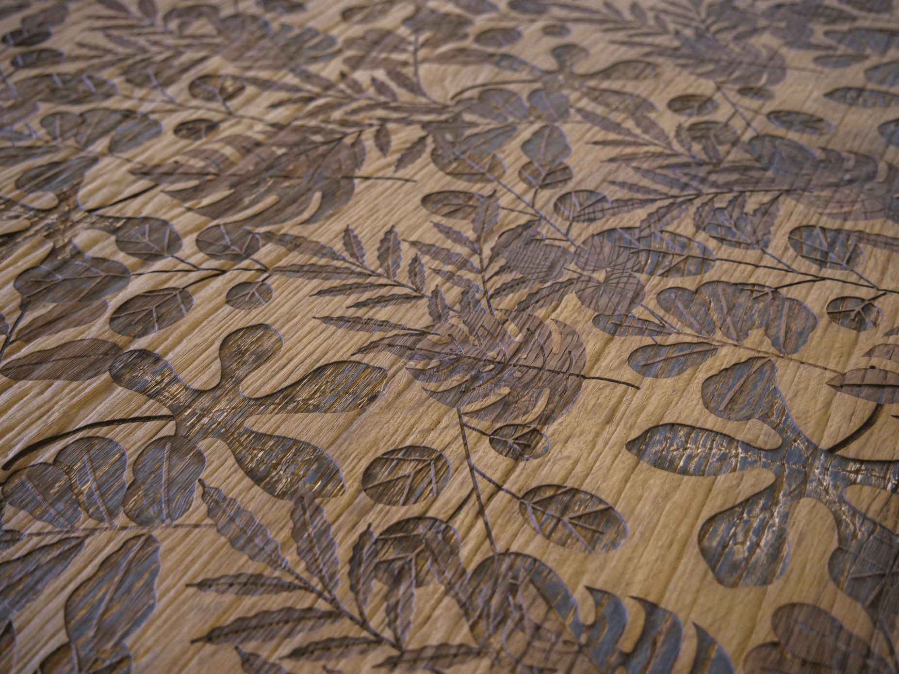 Keplinger zeigt eine Holzgravur in der Nahaufnahme mit schönem Muster bestehend aus Blättern in verschiedenen Größen und Formen.