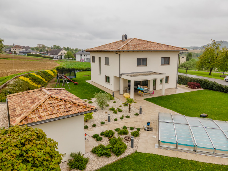 Einfamilienhaus mit Satteldach aus Tonziegeln, überdachter Terrasse und freistehender Garage von B. Kern Baugesellschaft.