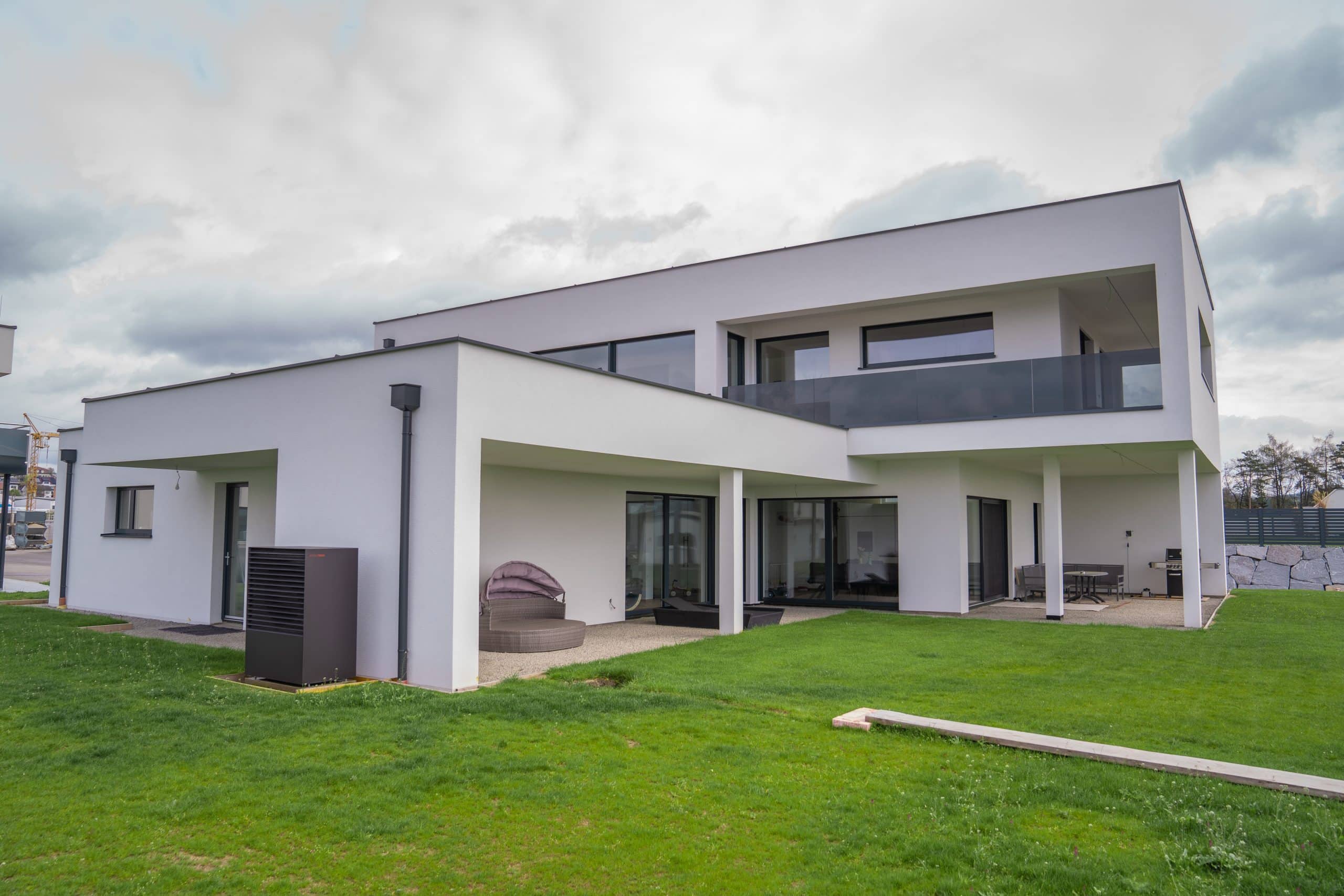 Modernes kubisches Haus mit dunkel verglastem Balkongeländer und bodentiefen Fenstern von B. Kern Baugesellschaft.