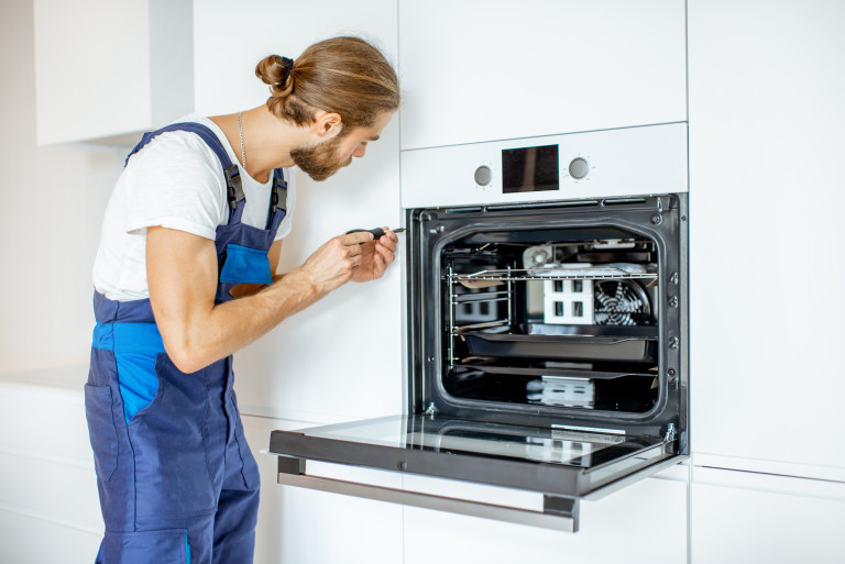 Techniker beim Einbau eines Backofens von LVI Haustechnik.