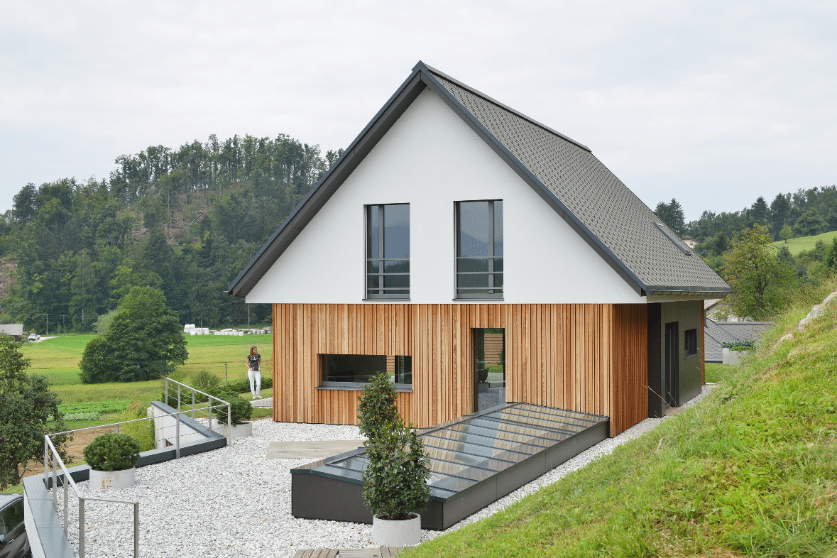 Einfamilienhaus mit teilweiser Holzverkleidung Terrassentüren und Fenstern von M SORA.