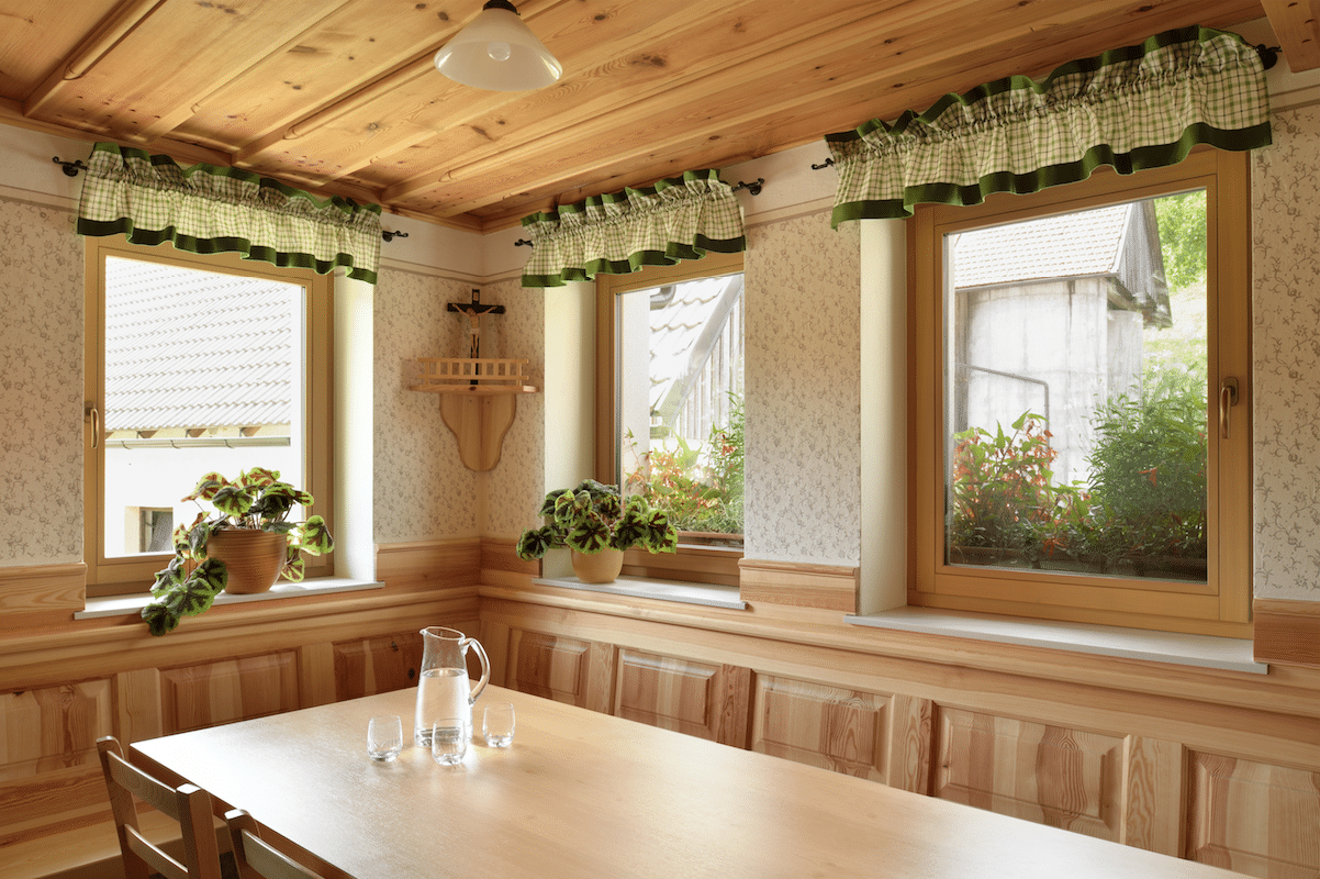 Traditionelle Stube mit Holzdecke, Eckbank und Holzfenster von M SORA.