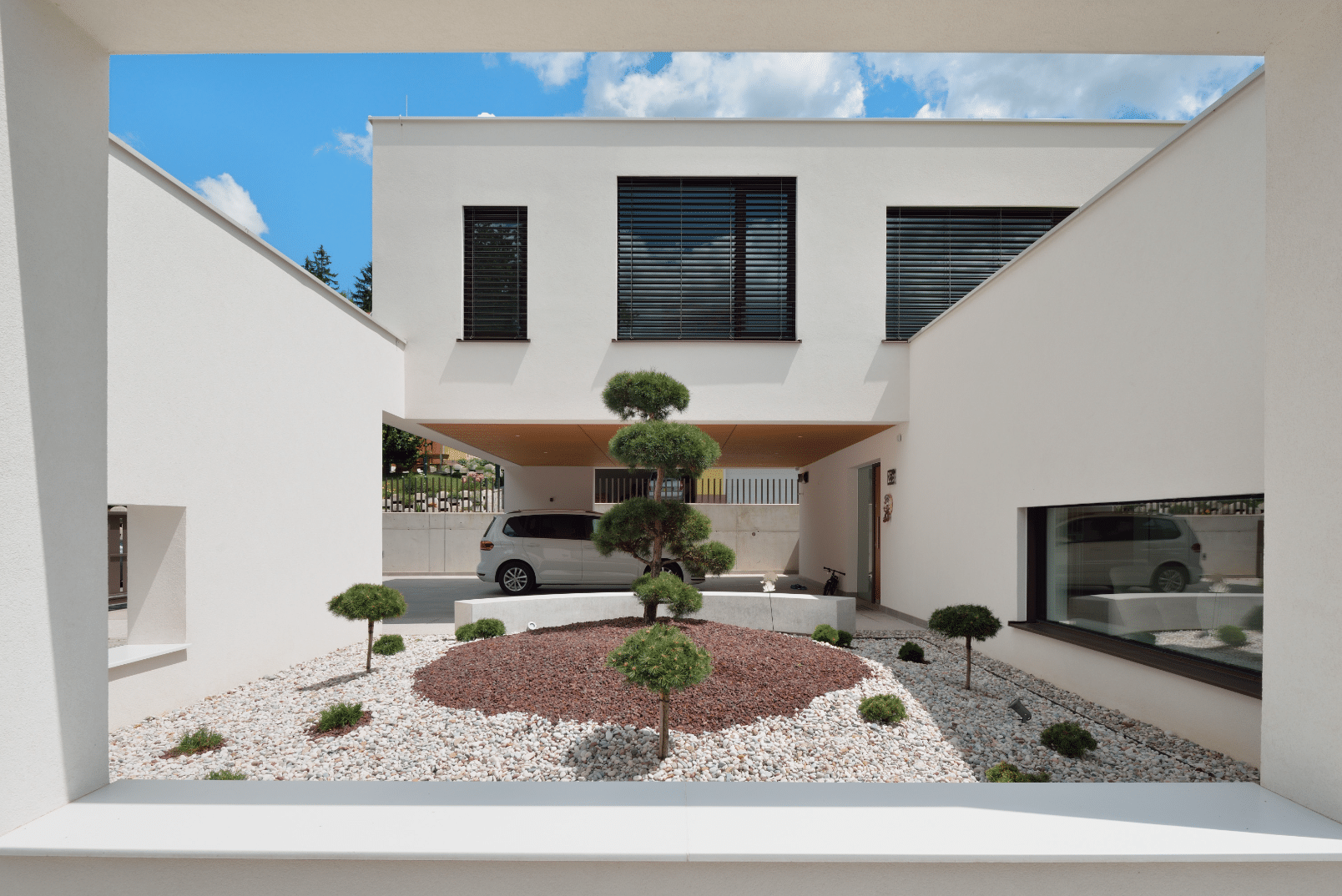 Modernes, kubisches Architektenhaus mit Innenhof, M SORA Vollverglasung sowie deckenhohen, barrierefreien Schiebetüren zur Terrasse hin.