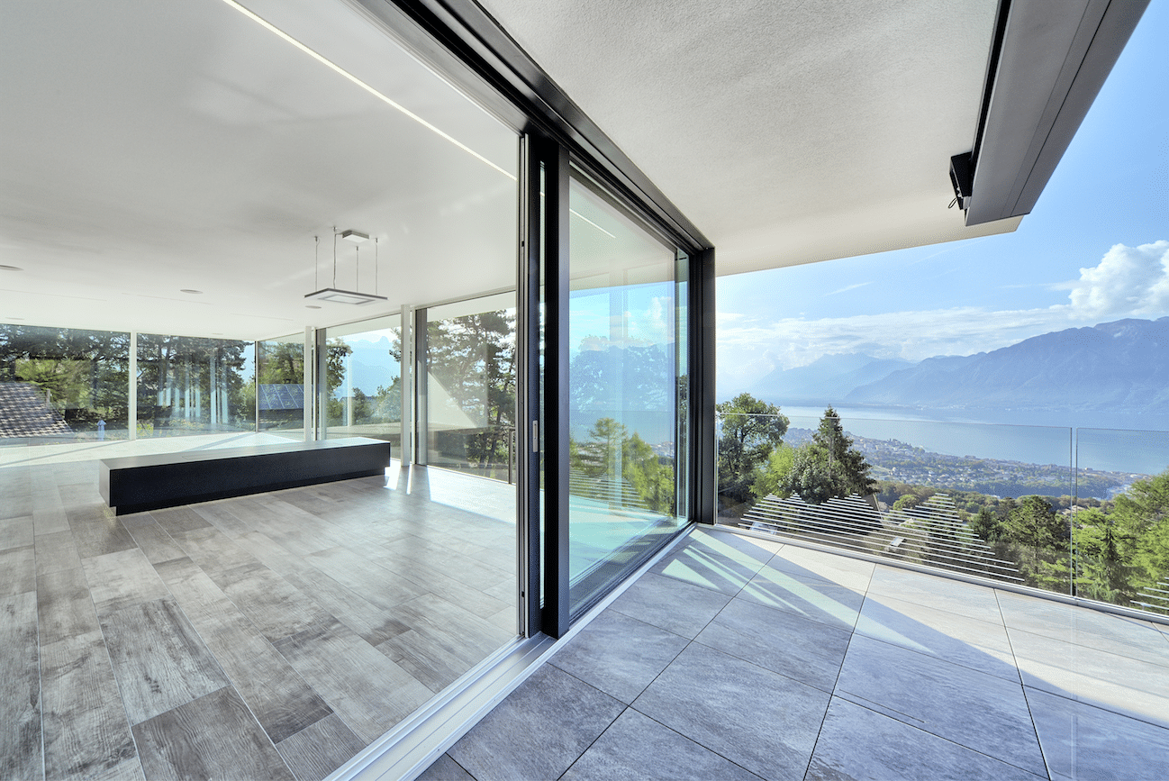 Balkon mit Panoramablick und barrierefreier Glasschiebetür von M SORA sowie einem Balkongeländer aus Glas.