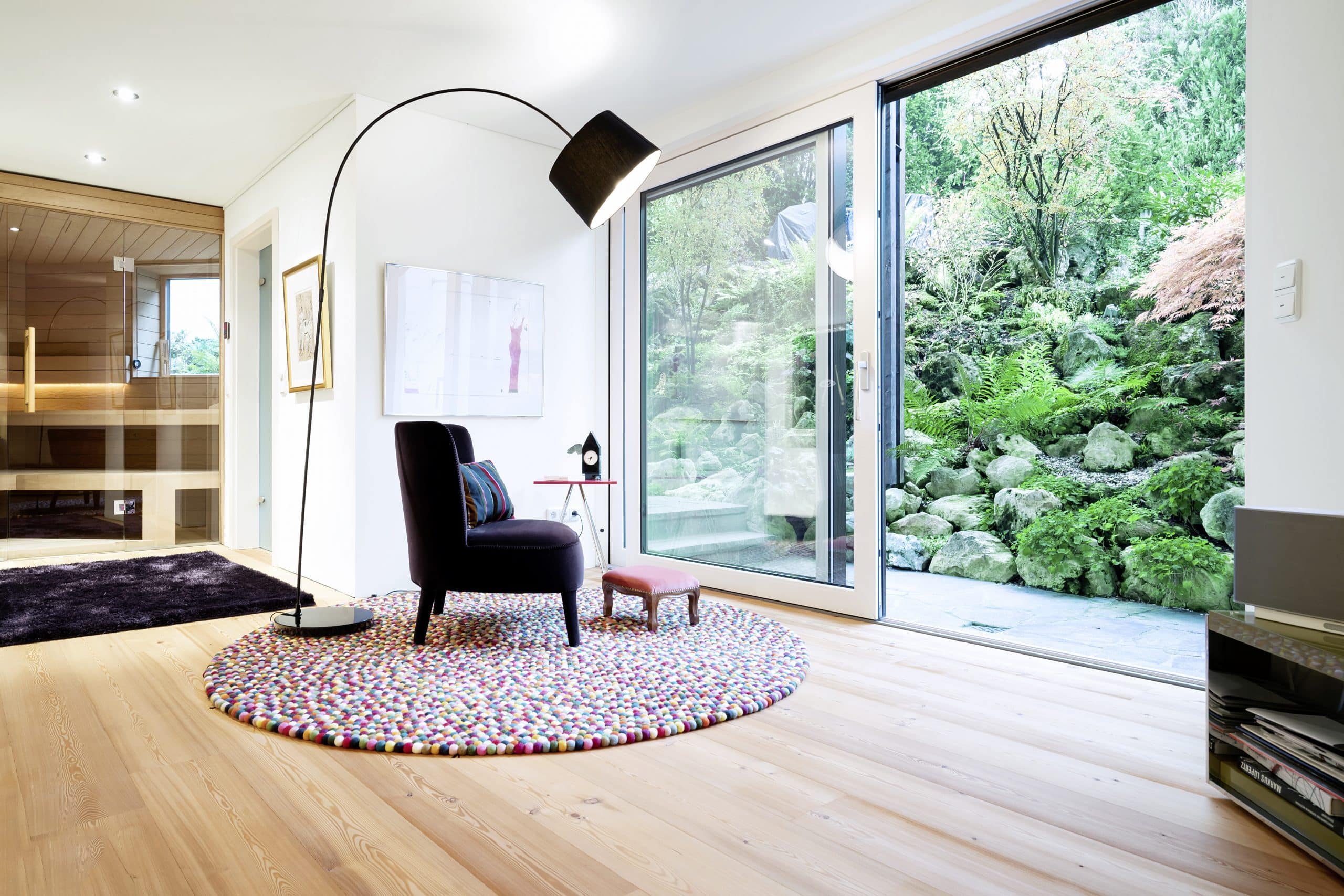 Mafi Naturholzboden zeigt den Boden eines sehr modernen Wohnzimmer mit einer schönen Stehlampe und einer Sauna im Hintergrund.