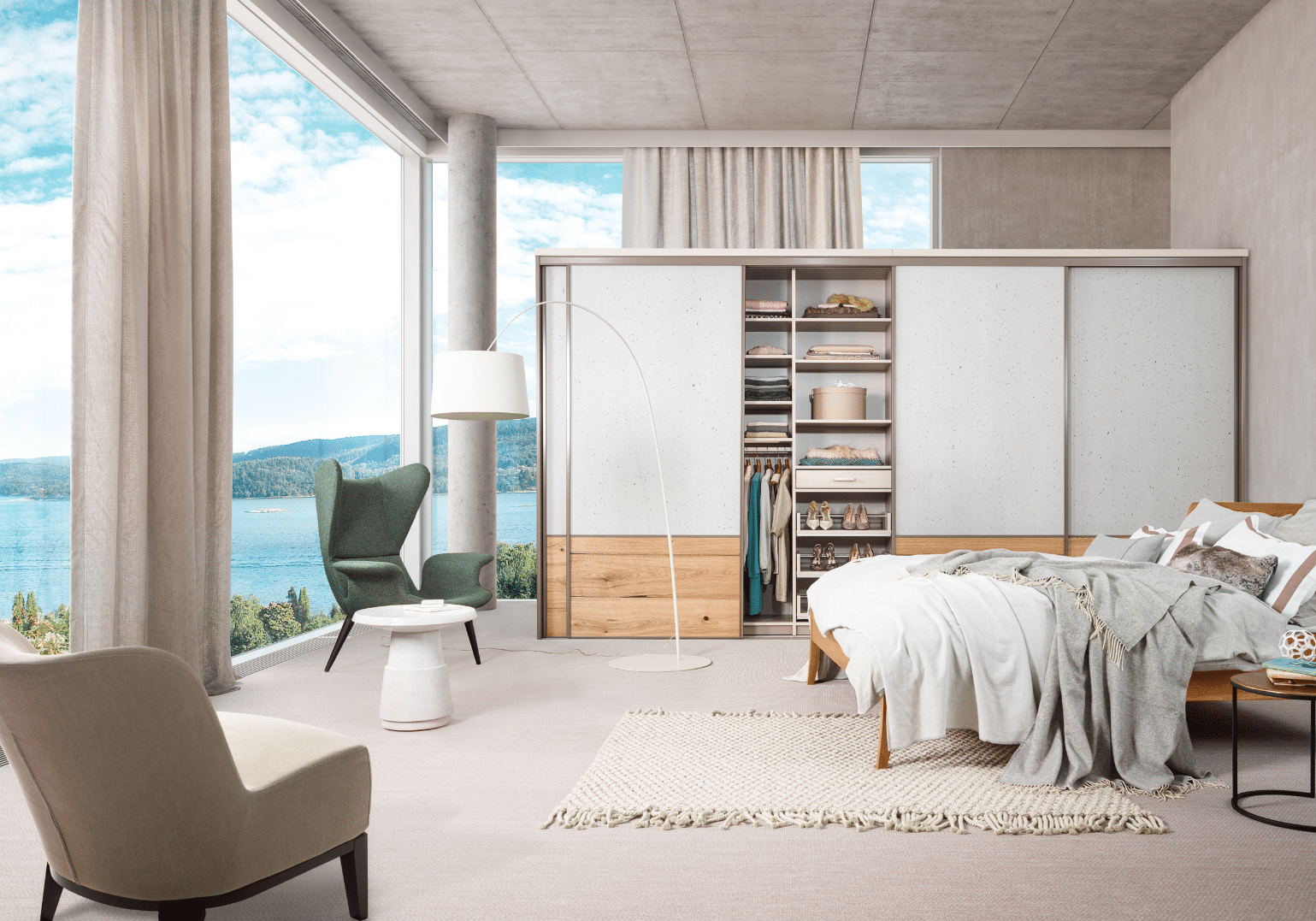 Mühleder Cabinet zeigt ein helles Schlafzimmer mit großflächigen Glaswänden, tollem Ausblick und einem Kleiderschrank mit Schiebetüren.