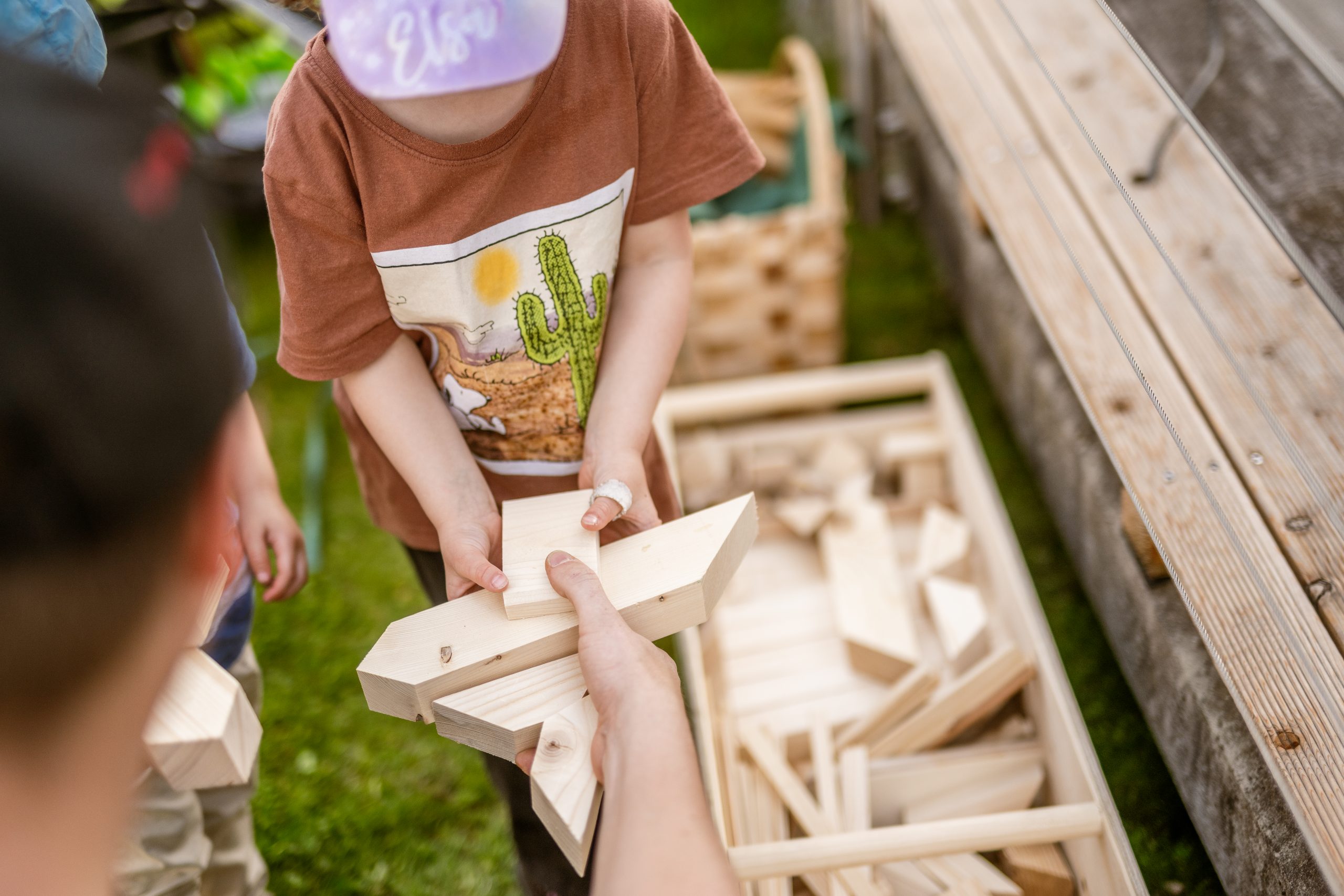 Mit Holzbauteilen wird Kindern im Musterhauspark Graz spielerisch näher gebracht wie ein Haus gebaut wird.