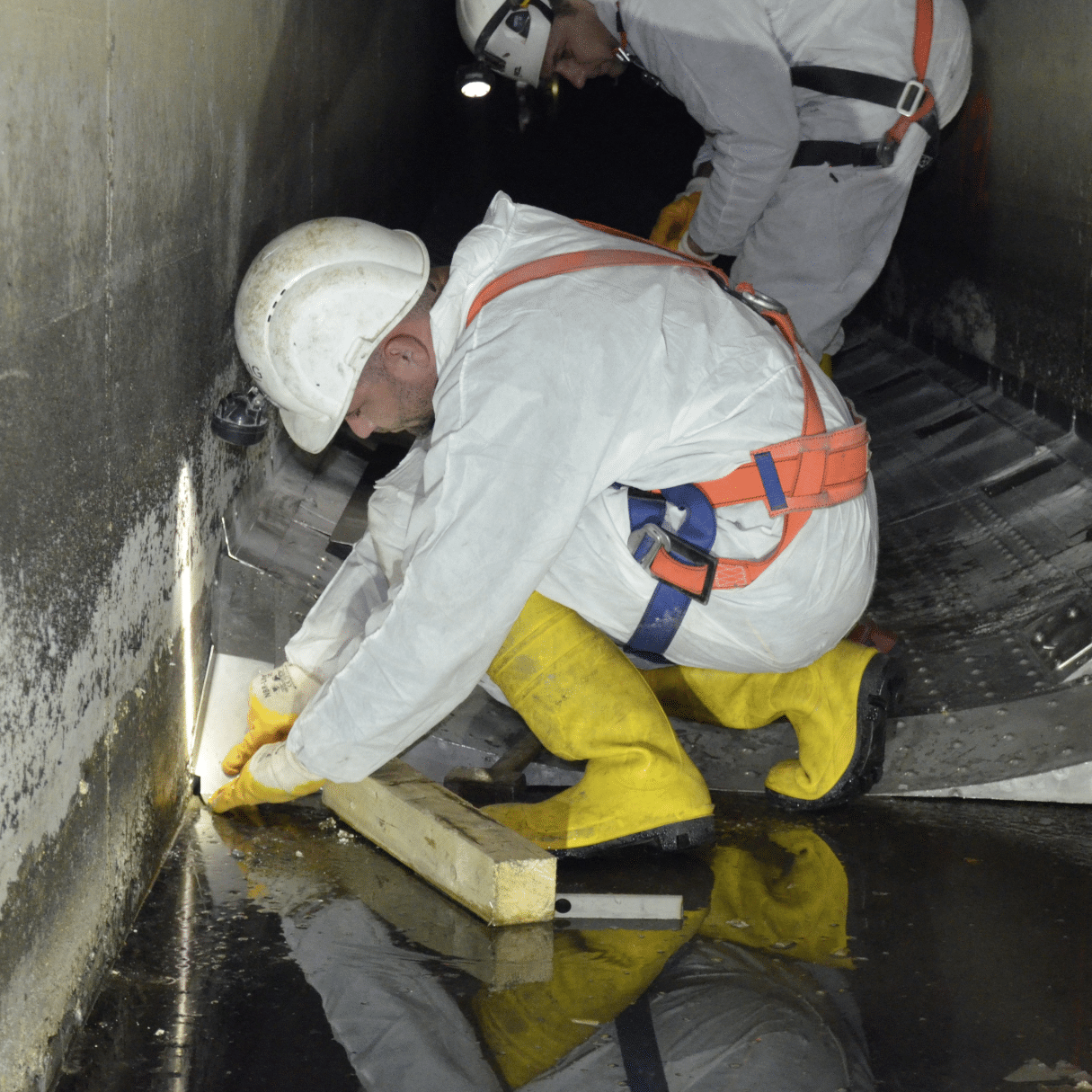 Arbeiter im Wien Kanal bei der Montage von Wärmetauschern.