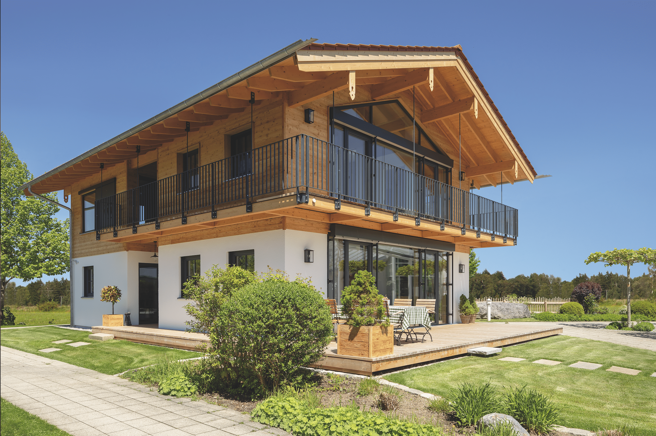 Außenansicht des Regnauer Musterhauses "Liesl", ausgestattet mit einem großen Eck-Balkon und einer teilweise überdachten Terrasse.