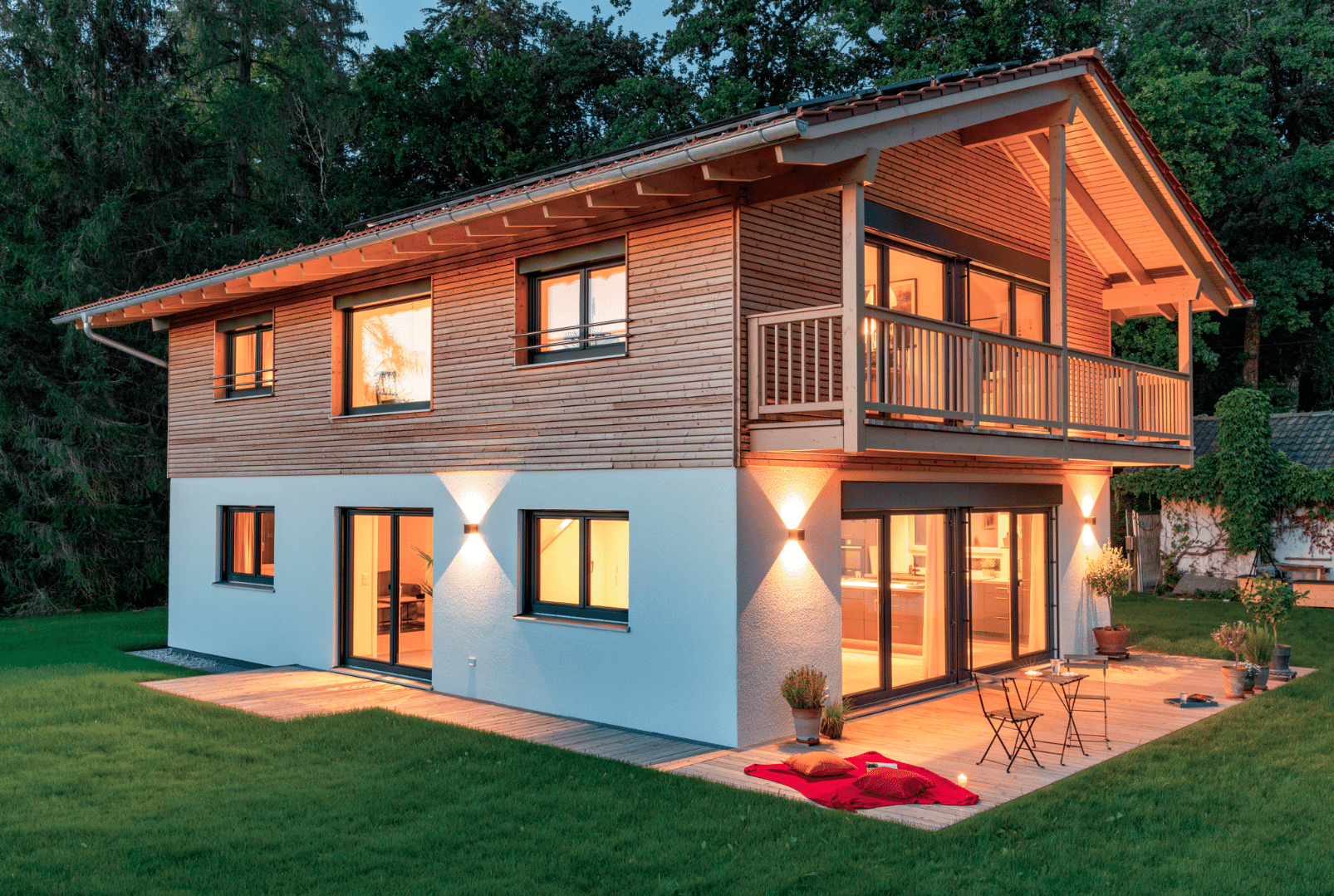 Einfamilienhaus von Regnauer Fertighaus mit Satteldach, teilweiser Holzverkleidung und großem Balkon.