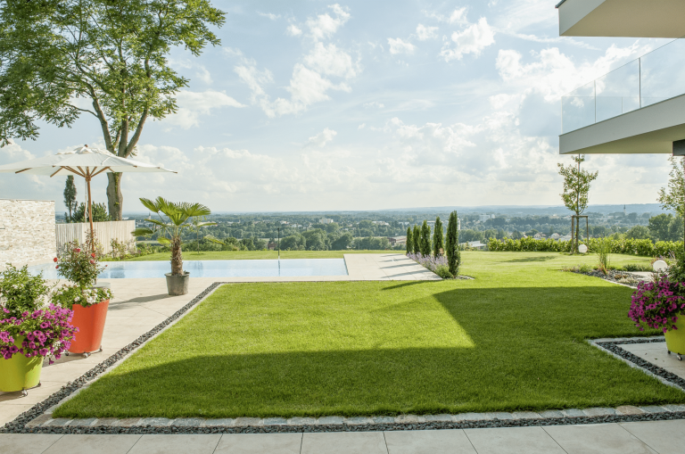 Gartenbau Schmid zeigt einen Garten mit sehr gepflegtem Rasen, Pool, verschiedenen Bäumen und Sträuchern.