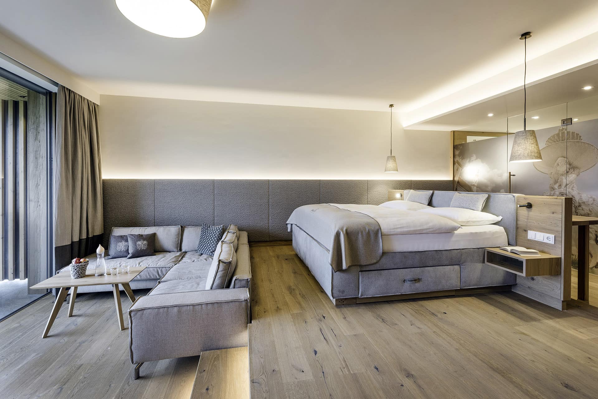 Elegantes Hotelzimmer im Genussdorf Gmachl mit Boxspringbett und gemütlicher Couch von sedda Polstermöbelwerke.