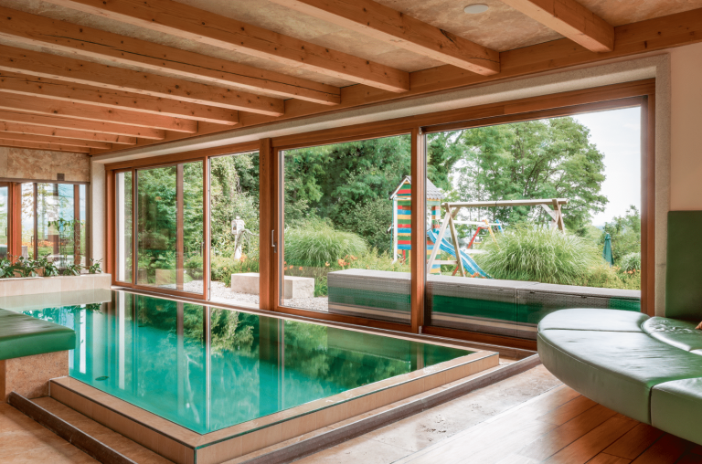 Silber Fenster zeigt ein indoor Swimmingpool mit großen Glasfronten und einer Glasschiebetür.