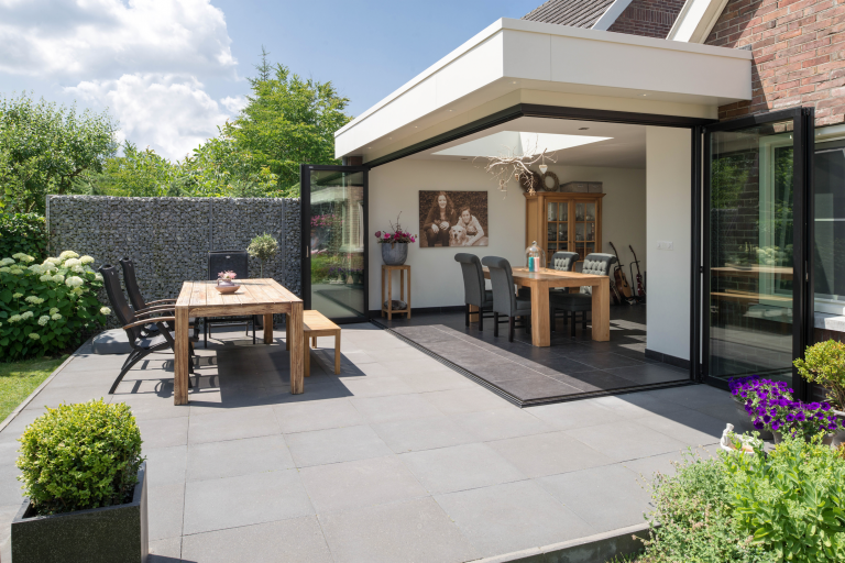 Wohnhaus mit Terrasse und Wintergarten mit Glasfront mit deckenhohen Glas-Falt-Schiebetüren von Solarlux.