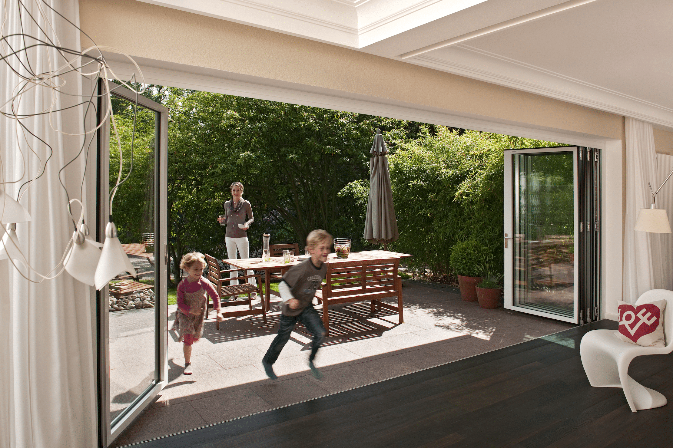 Wohnhaus mit Terrasse und Glasfront mit deckenhohen Glas-Falt-Schiebetüren von Solarlux.