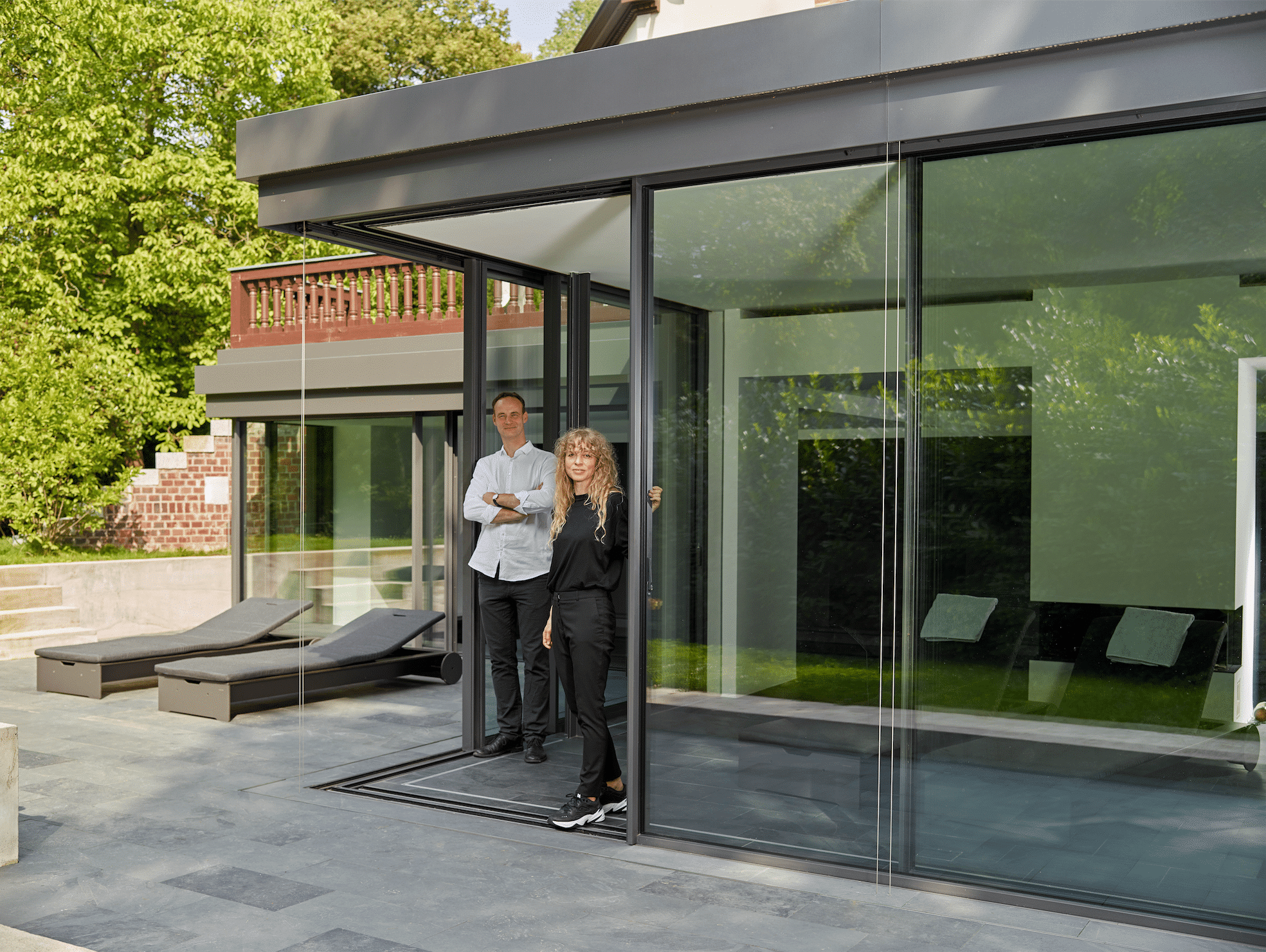Betriebsgebäude mit Terrasse und deckenhohen Glas-Schiebetüren von Solarlux.