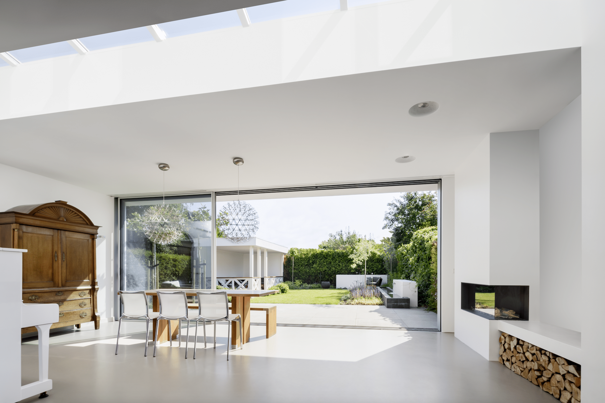 Offener Wohnraum mit geöffnetem Ganzglas-Schiebesystem von Solarlux.