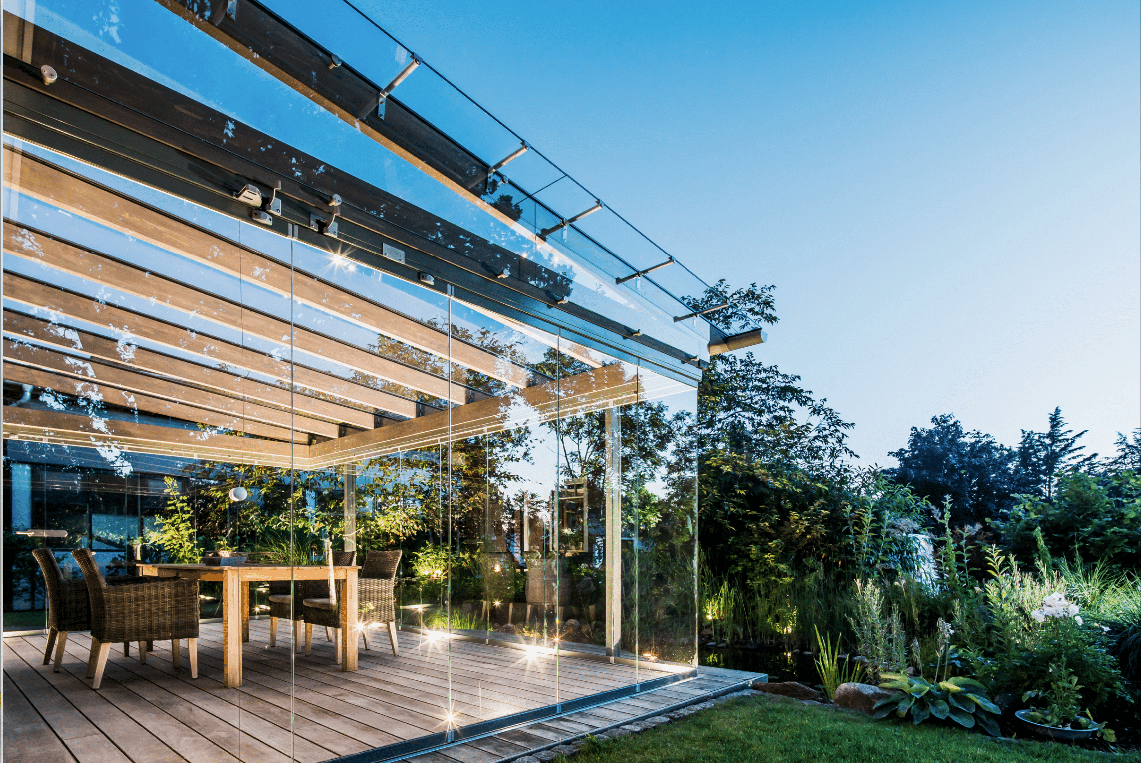 Rundum verglaste Terrasse mit rahmenfreien Solarlux Schiebetüren und Glasdach.