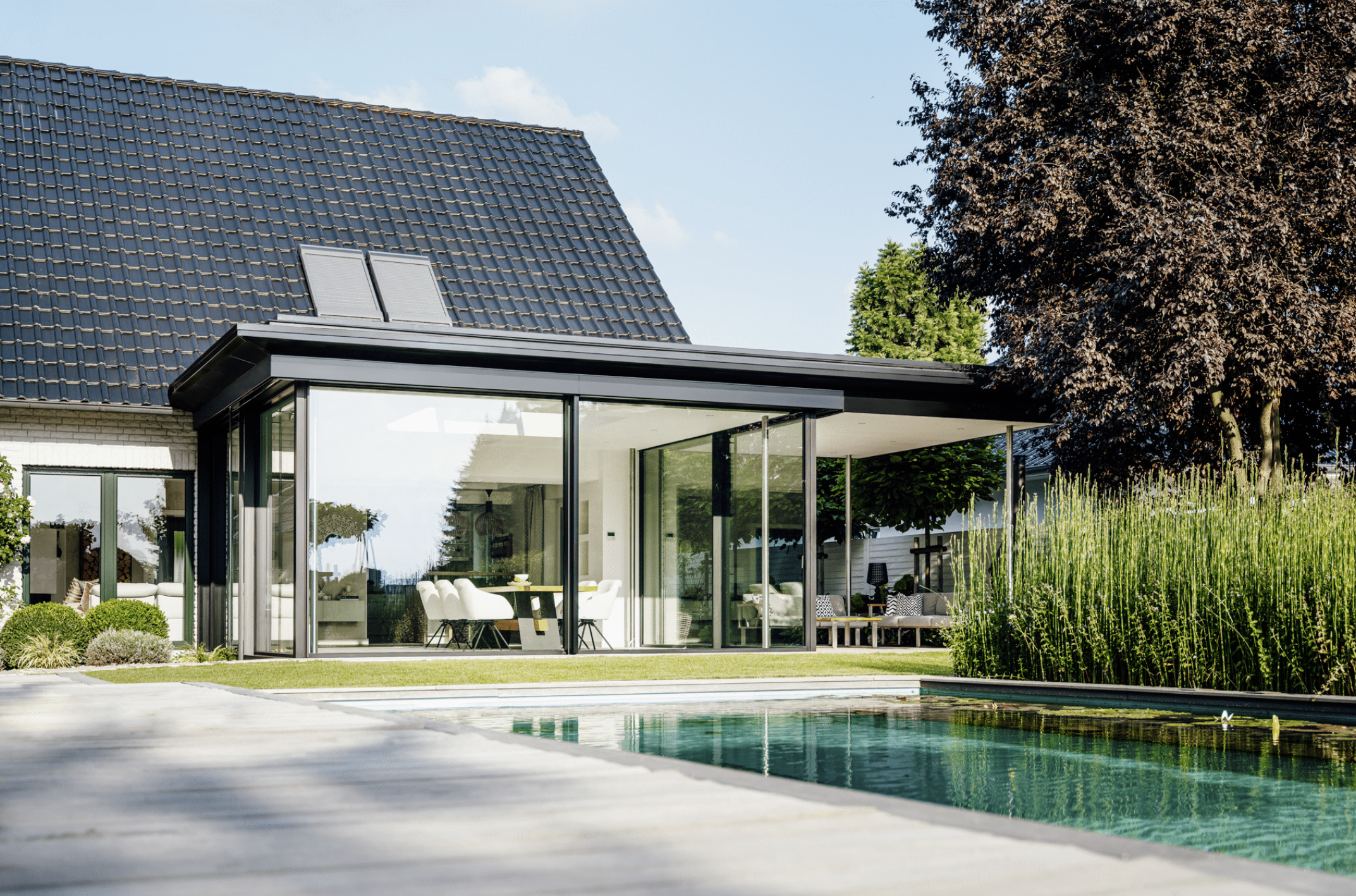 SOLARLUX präsentiert den Wintergarten eine Einfamilienhauses mit Glasschiebetüren, einem Pool und großem Garten.