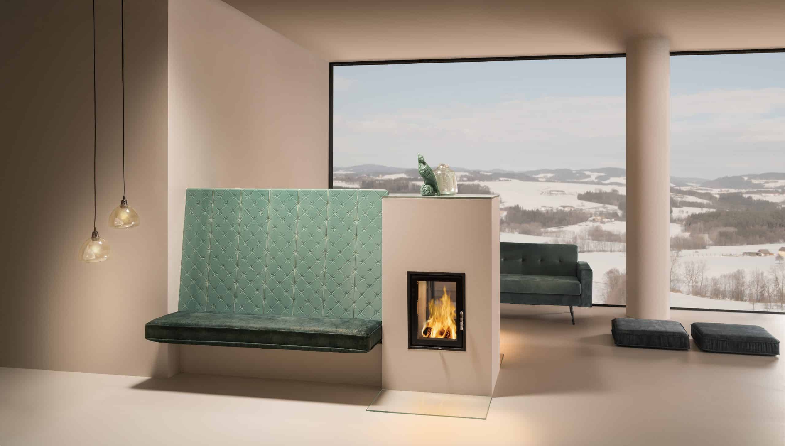 Sommerhuber präsentiert einen gemütlichen Kachelofen im trendingen Chesterfield-Design in Türkisgrün und großem Sichtfenster zur Feuerstelle.