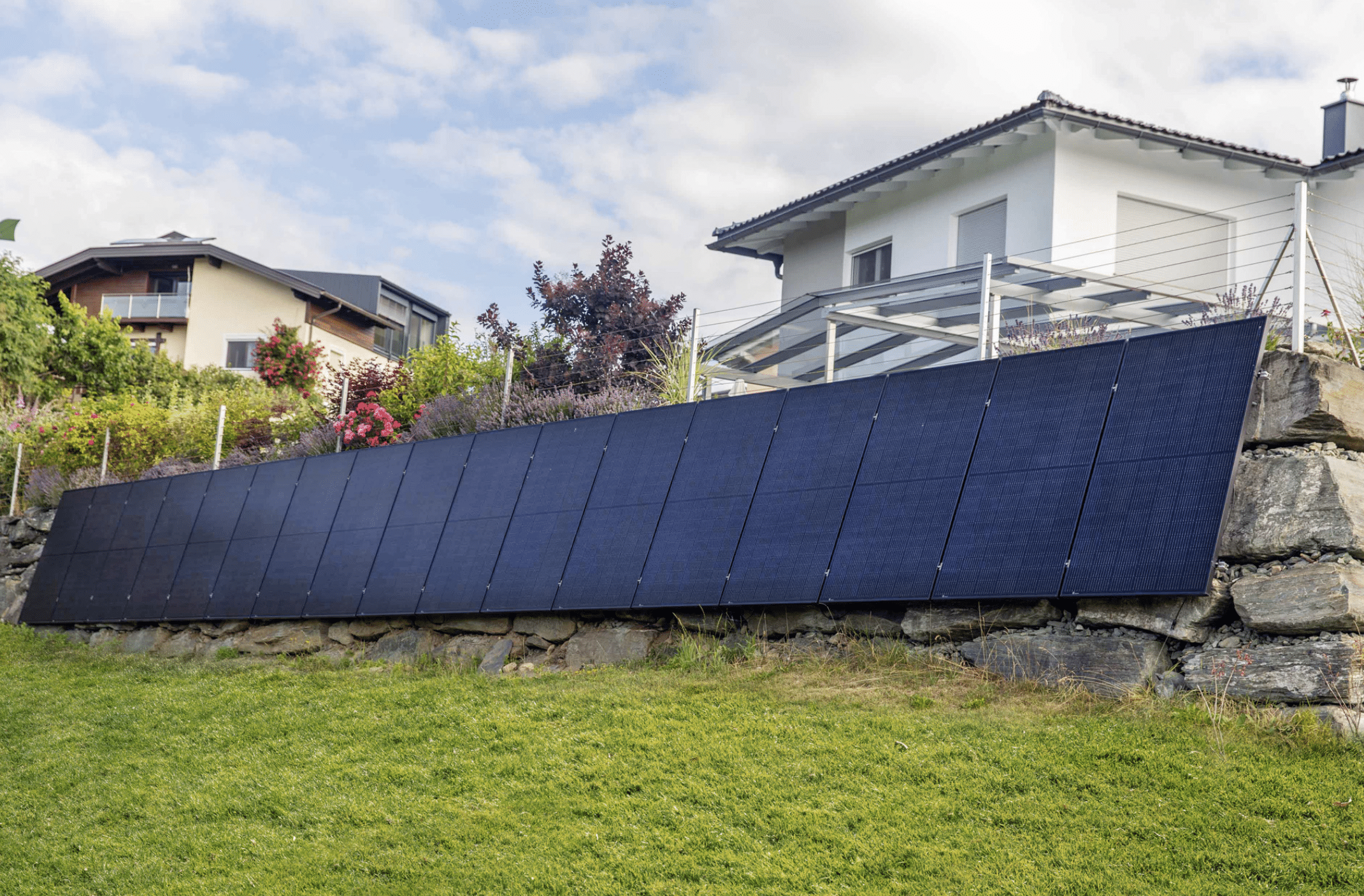 SONNENKRAFT präsentiert eine Photovoltaikanlage, welche an einer Steinmauer befestigt wurde um Platz im Garten zu sparen.