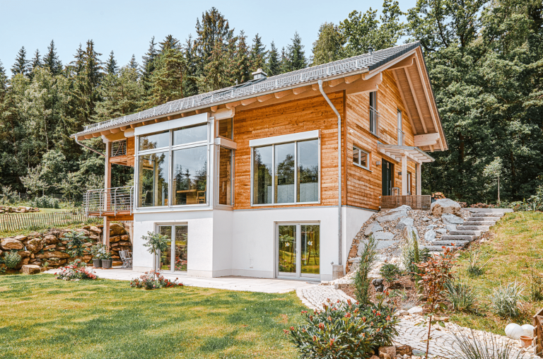 Atemberaubend fügt sich das Holzhaus von Sonnleitner Holzbauwerke in die Umgebung ein und zaubert einen unvergesslichen Blick ins Grüne.