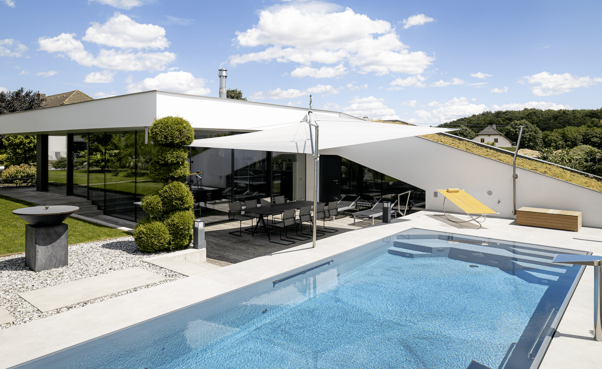 Swimmingpool nebst großzügiger Terrasse mit modernem Sonnensegel von SunSquare.