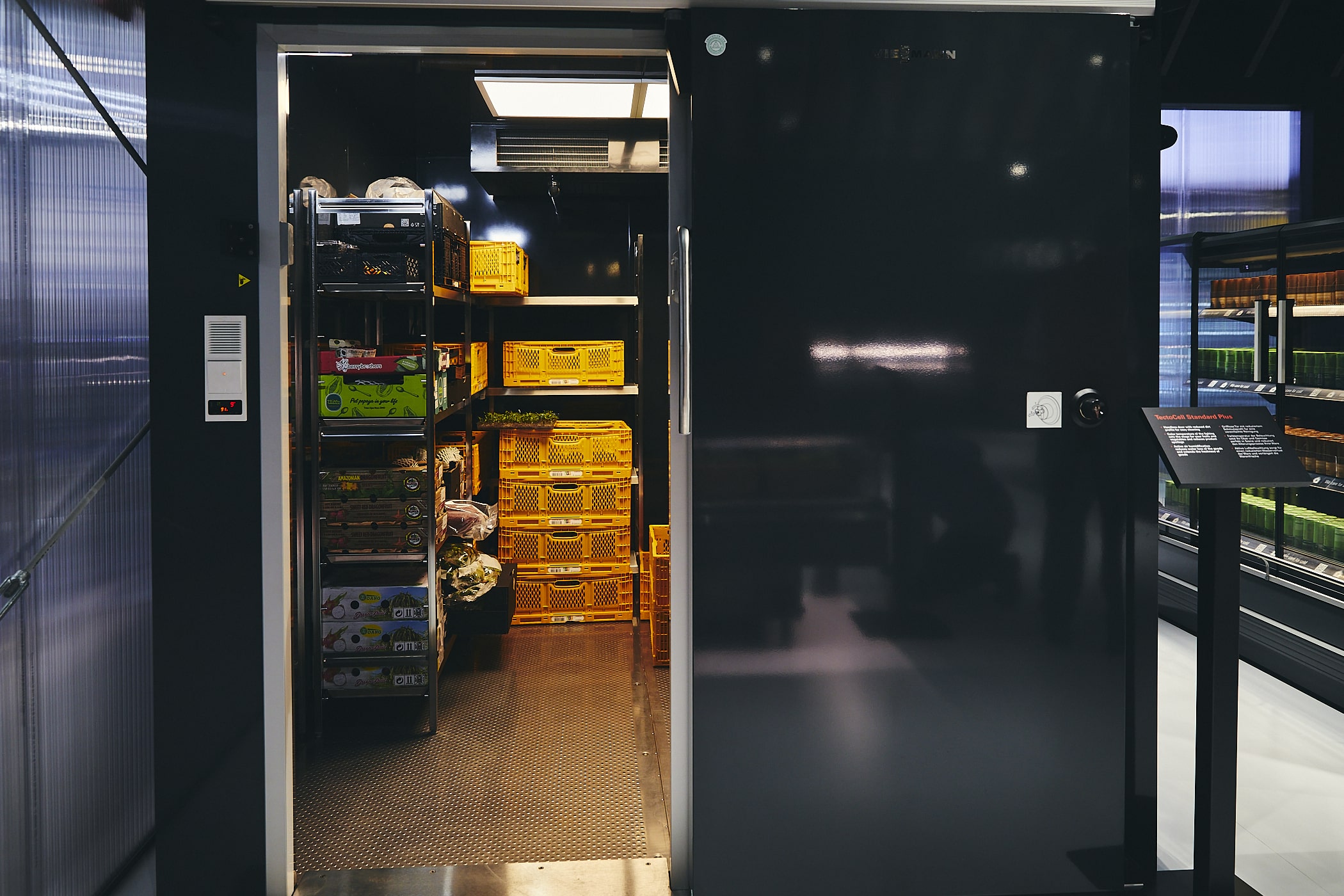 Schwarz, glänzende Kühlzelle von Viessmann mit geöffneter Tür und eingeräumten Regalsystem.
