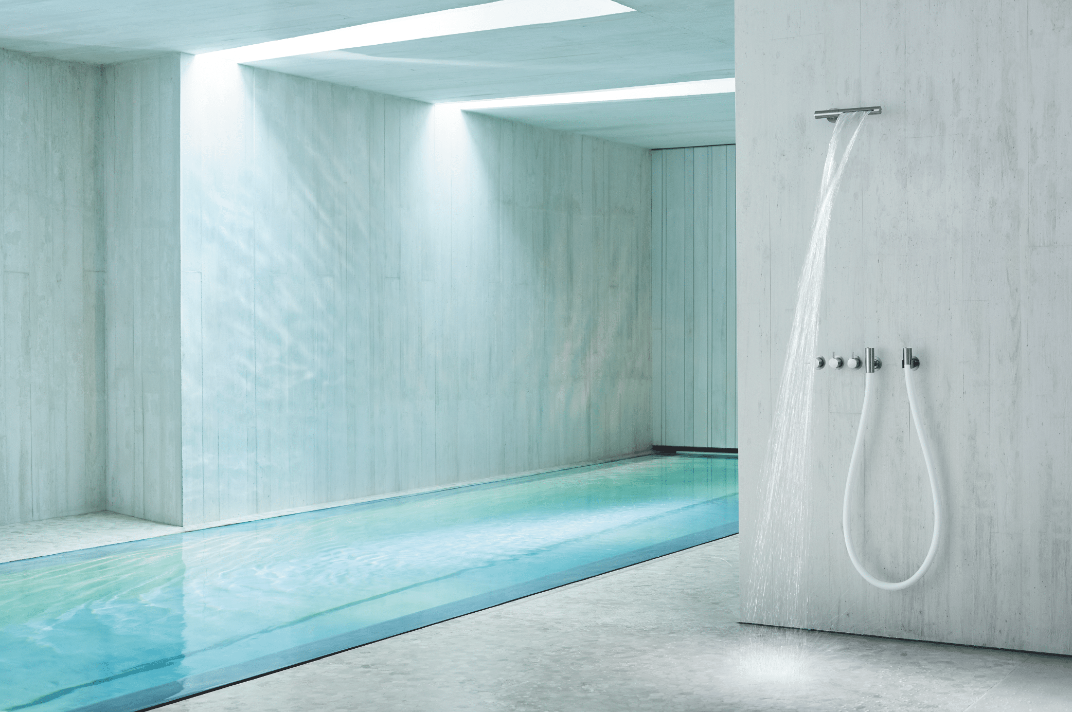 VOLA zeigt einen Spa-Bereich mit Pool und offener Dusche mit silbernen Armaturen.