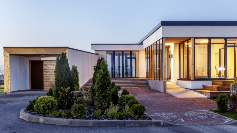 Moderner Bungalow mit Flachdach, Garage, bodentiefen Fenstern und Fixverglasung von Weissenseer Holz-System-Bau.